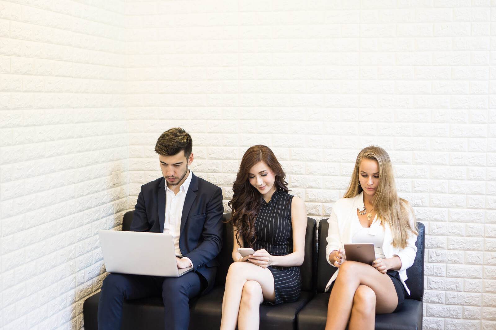 A Group Of Business People Sitting On A Bench With Laptops, Wondering About The 5 Types Of Copywriting.