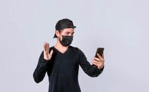 A man showcasing a creative selfie technique while wearing a face mask, exploring ways to earn through OnlyFans without revealing his identity.
