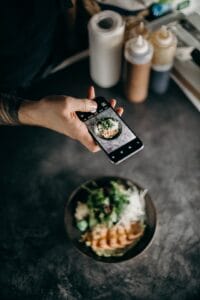 A person captures and shares a photo of a scrumptious plate of food to connect with their audience through brutally honest blogging.